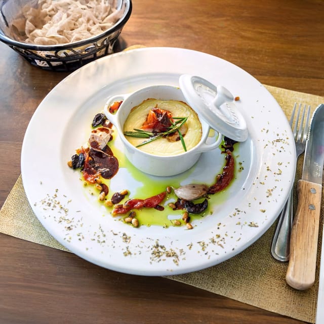 Pico Provencal, Fromage De Chèvre Servi Tiède, Ail Et Tomates Confites, Pignons Olives Noires, Jus D'agneau Et Huile De Basilic Maison.
